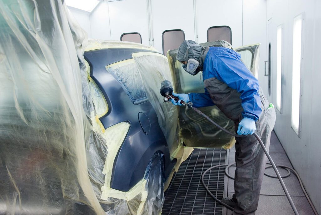 Spray painter repairing car